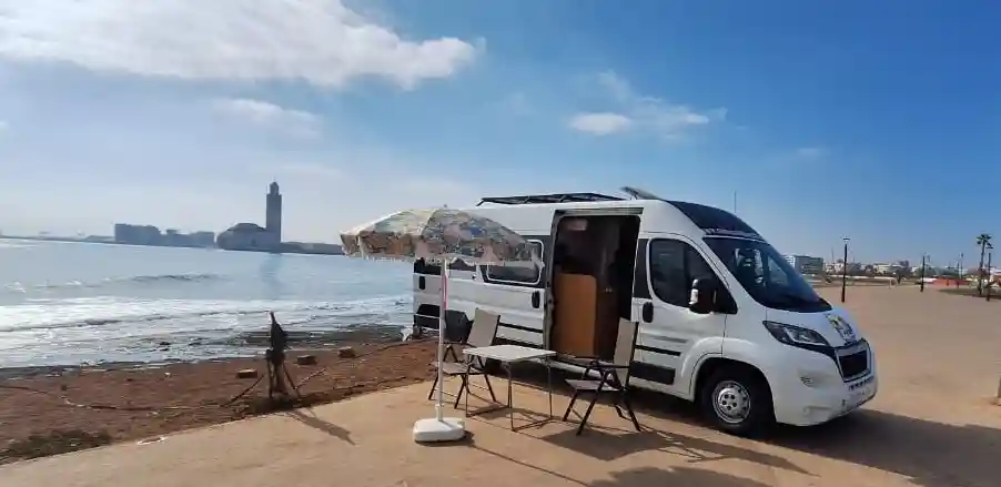 Rent a Camper Van in Morocco | Airport Transfers | Voyage en Camping-Car au Maroc : Itinéraire Agadir – Mirleft – Sidi Ifni Camping-car avec mosquée Hassan II en arrière-plan Camper van with Hassan II Mosque in the background